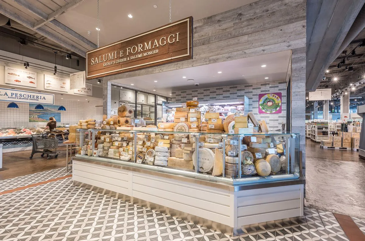 The cheese and salumi counter at Eataly Los Angeles, with wheels of aged cheese stacked on display