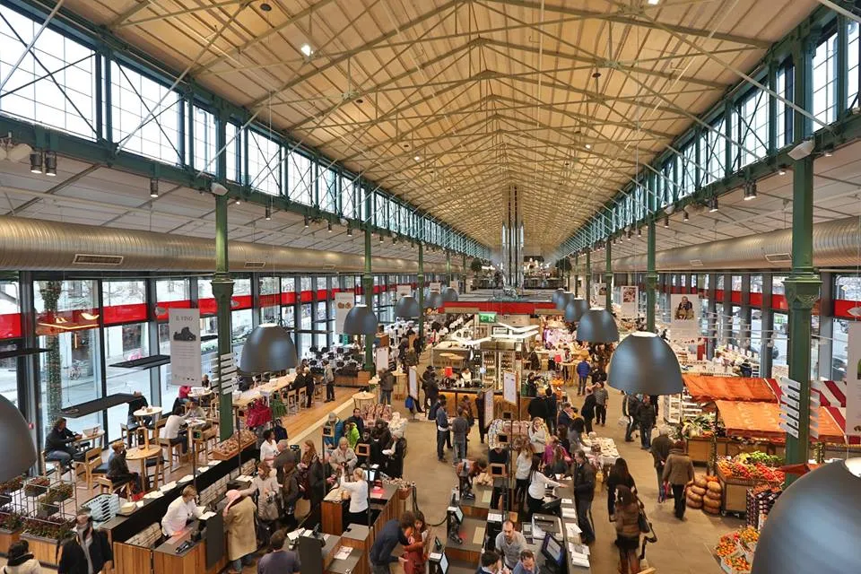 Eataly Munich, showing the warm market-hall atmosphere with wooden signage and food stalls