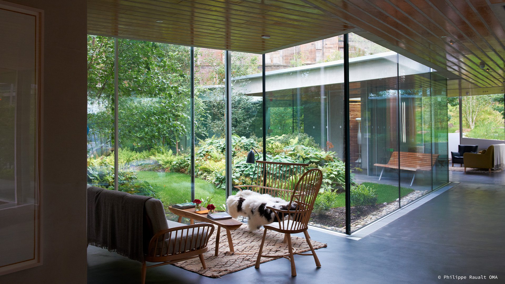 Interior of a Maggie's Centre with glass wall looking onto a green garden