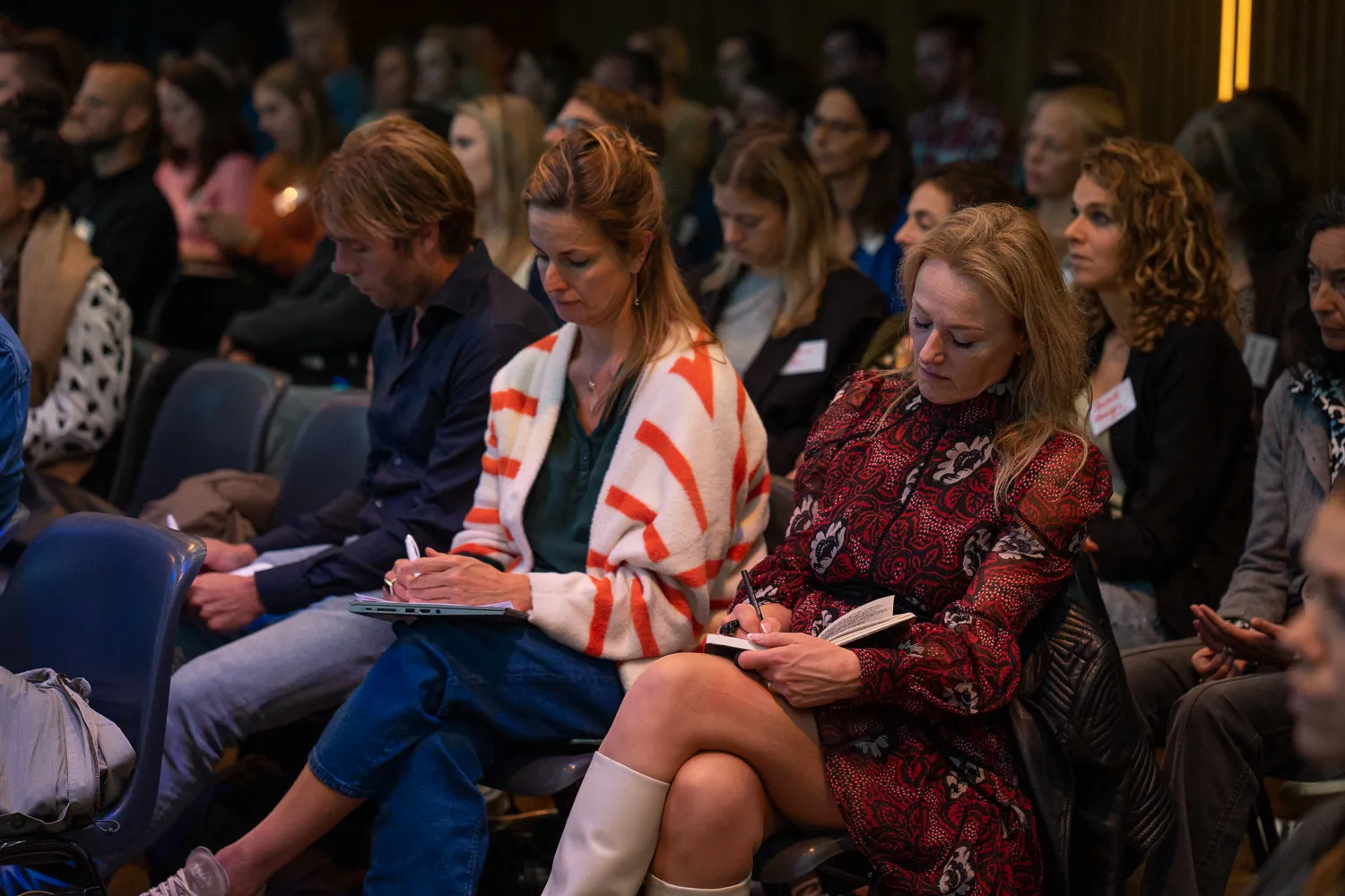 Deelnemers aan het Behavioural Design Fest maken aantekeningen tijdens een talk