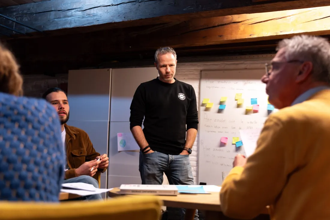 Participants mapping the forces behind a decision on a wall covered in post-its