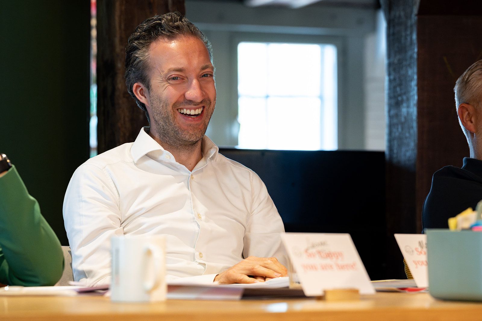 A participant laughs at the table during a SUE training