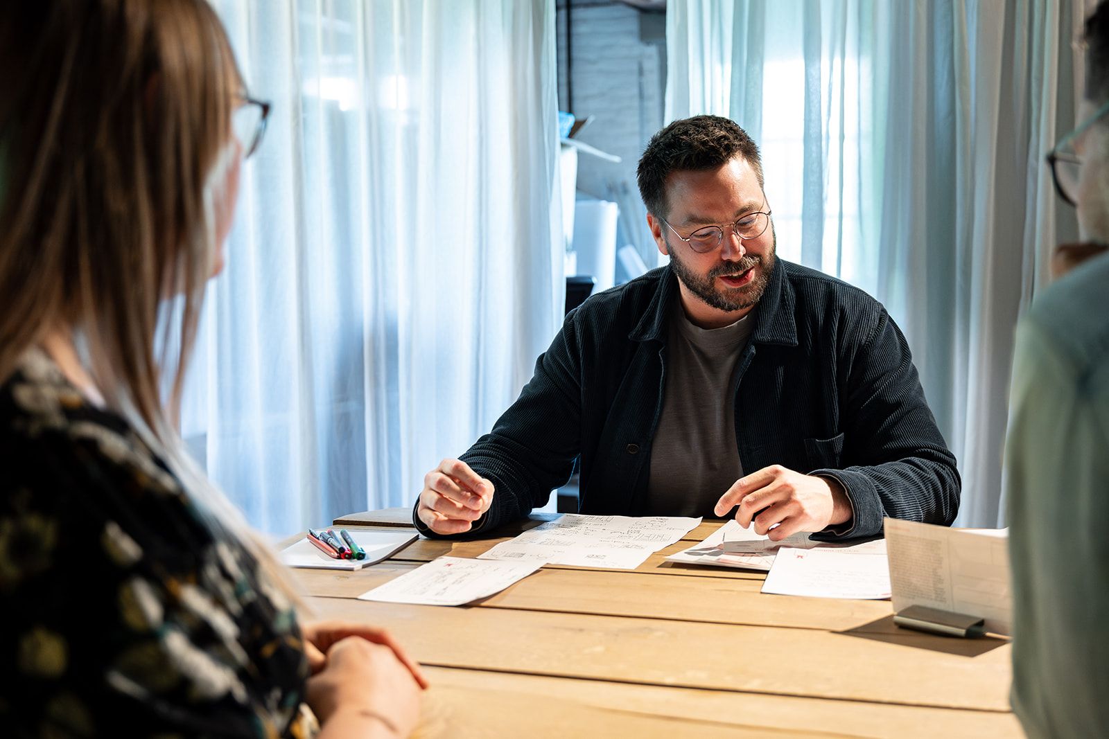 Een deelnemer werkt aan tafel aan een opdracht tijdens een SUE-training