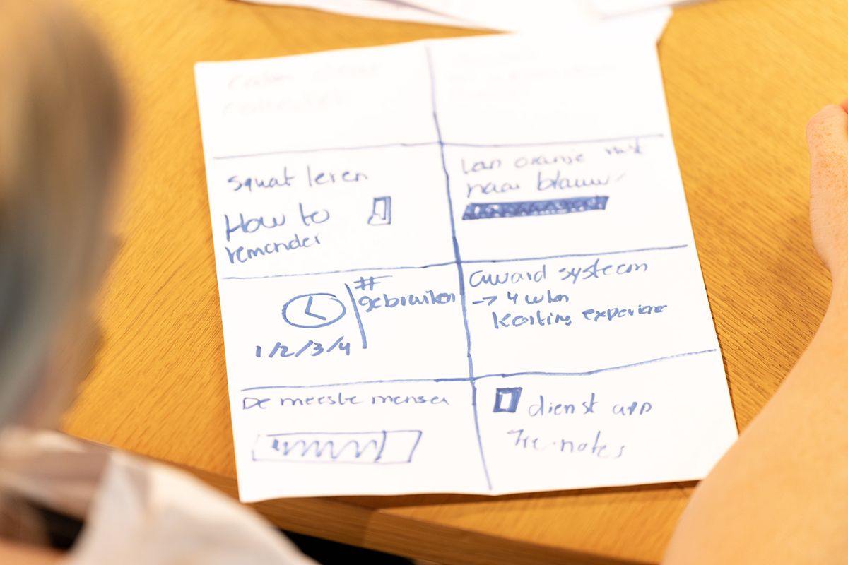 Een handgeschreven werkkaart met ideeën op tafel tijdens een SUE-training