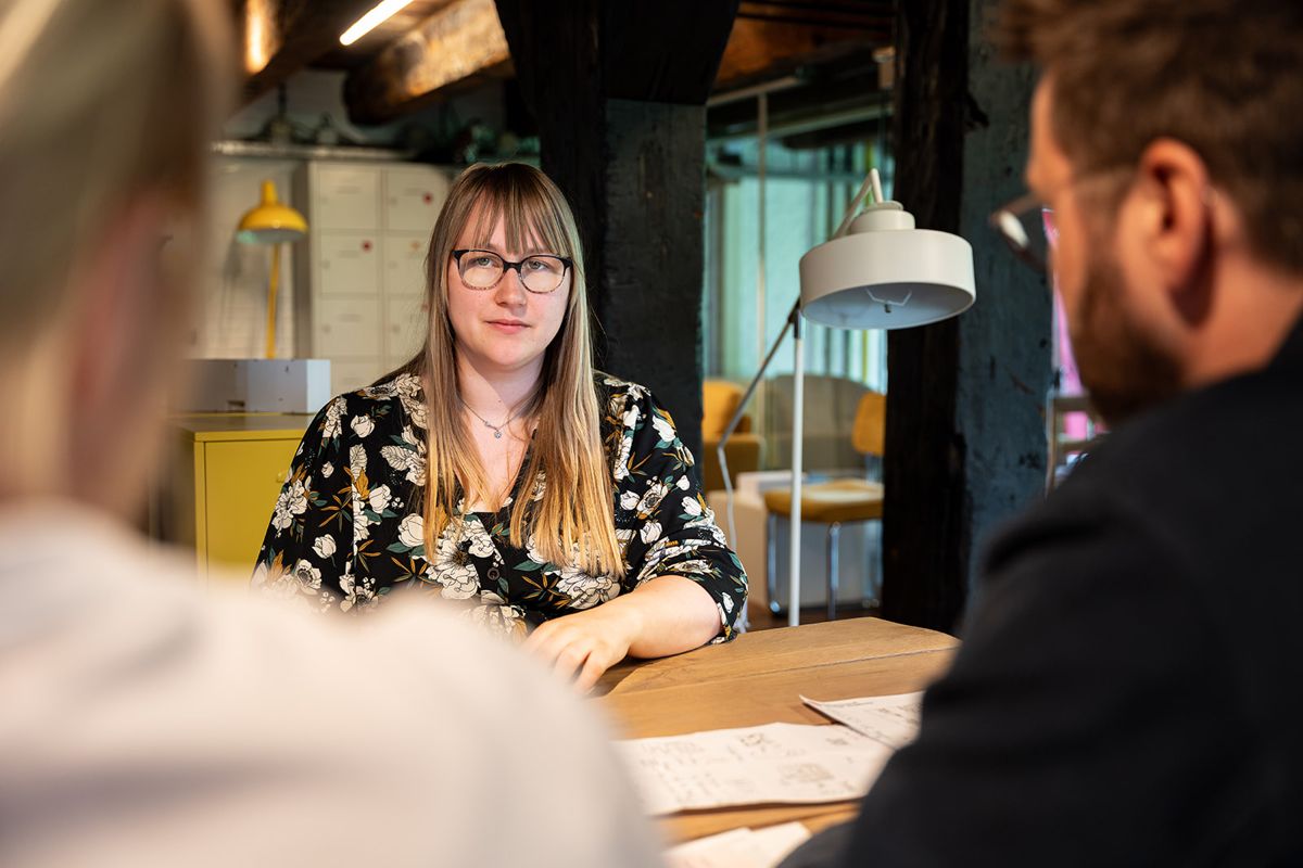 A participant listens at the table during a SUE training