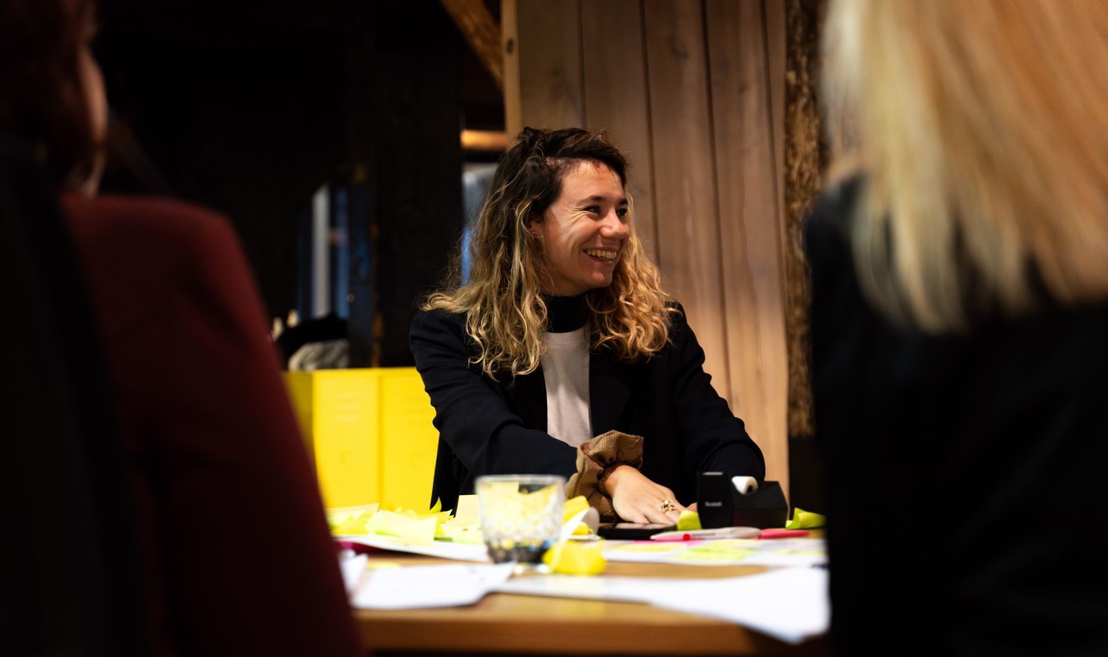 Een deelnemer lacht aan een werktafel met post-its tijdens een sessie bij SUE in Amsterdam